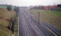 Looking south to Glengarnock station in 1997. The Lanarkshire and Ayrshire crossed over here on its route to Kilbirnie, which also served the Glengarnock Iron and Steel Works. By this date, the embankments on both sides had been largely eradicated although some hedge lines gave away where they had run. The siding to the right ran ahead to the goods yard, iron and steelworks. By 1997 it served a shed in the goods yard and ran for a very short length toward the former works having been cut back a few years before.<br><br>[Ewan Crawford //1997]