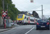 SNCB EMU 08099 rumbles over the level crossing in Dinant as it slows for the station with a service from Brussels Airport that has travelled down the scenic Meuse Valley from Namur. One last railway picture as we headed back to the UK. 10th September 2017 <br><br>[Mark Bartlett 10/09/2017]