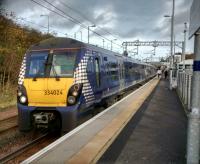 A Milngavie service at Livingston North on 24th October 2017. Neither of the Livingston stations are at all central: North is in Deans and South in Murieston. Even the pre-newtown Livingston station was so far from the village that a separate,<br>
larger community grew up around it. 'Livingston Station' was larger than<br>
Livingston village - though this wouldn't be difficult.<br>
<br>
<br><br>[David Panton 25/10/2017]