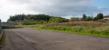 This view looks west at the site of Eglinton Iron Works at the point where the closed Doura branch (now the road) came in under the Kilwinning to Byrehill line (on which a 380 is heading south) and lines curved into the works from the Kilwinning direction off to the right.<br><br>[Ewan Crawford 14/09/2017]