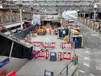 The demolition of the Platform 11 buildings has ostensibly reached half-way on 9 October as the upper storey has now gone. Once the building is history excavation can start on the extension of bay Platform 12 from behind the building. The buffers will be in the foreground of the picture. The escalator will be resited; for the time being passengers have to use the stairs.<br><br>[David Panton 09/10/2017]