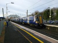 A North Berwick service pulls into Longniddry, on the cold morning of 9th<br>
December 2017, while Christmas shoppers await the next Edinburgh train due in a<br>
few minutes. Despite the single line branch from Drem Scotrail can easily<br>
manage the half-hourly North Berwick service on Saturdays but it's only hourly Monday to Friday. Does anyone know the reason for this longstanding timetable oddity?<br>
<br><br>[David Panton 09/12/2017]