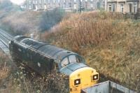A class 37 shunts an engineering train out of the engineer's siding in Haltwhistle Station yard. Photograph taken from the old A69 overbridge looking west towards Carlisle in October 1989. [Ref query 17 January 2017] For a view of this loco looking across to the station area [see image 62576].<br><br>[Charlie Niven /10/1989]