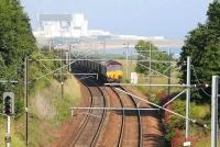 Torness Nuclear Power Station dominates the background as a Hunterston – Drax coal train rounds the curve north of Cockburspath on a fine day in the summer of 2007.<br><br>[John Furnevel 30/06/2007]