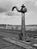 NER water column, located between the Down Main and Down Loop, to the north of Belford in 1987. An electrification mast in the background signals its demise, hopefully removed to a preservation site.<br>
<br>
<br><br>[Bill Roberton //1987]