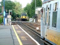 Comings and goings at the north end of Brockenhurst station in the summer of 2002, with trains about to pass over Lymington Road level crossing.<br><br>[Ian Dinmore 26/07/2002]