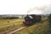 Peckett and Sons 0-4-0ST No 2003 <I>John Blenkinsop</I> hauls two preserved coaches up the incline towards Park Halt on the Middleton Railway Trust's line from Moor Road depot in Hunslet. This is the world's oldest continuously operating public railway. Its origin can be traced back to a waggonway authorised by Act of Parliament from 1758 to take coal from the pits at Middleton to a staith at Casson Close near the River Aire in Leeds. It is 205 years since steam locomotives were first used here on the initiative of the colliery Viewer, John Blenkinsop, who introduced a rack and pinion system with iron edge rails. [Ref query 24 December 2017]<br><br>[Charlie Niven //1989]