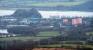 A Balloch bound train leaves Dalreoch as seen from the Carman Hill Fort. At the bottom right is Dalmoak House. The view includes the flats at Dennystown, the Old Dumbarton Bridge, Dumbarton, the Clyde, Dumbarton Castle, Dumbarton FC's stadium and the meandering River Leven.<br><br>[Ewan Crawford 16/02/2018]