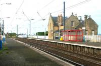 Colourful Kirknewton. Platform view west towards the level crossing in May 2003.<br><br>[John Furnevel 05/05/2003]