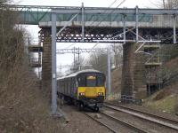 The 0817 to Whifflet passes under the Muirhead Road overbridge on 12th March 2018, the day after most of the bridge was expected to be removed during a line closure. More difficult to remove than anticipated, much of the bridge remains. <br><br>[Colin McDonald 12/03/2018]