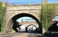 Looking north along Edinburgh's Inglis Green Road on Sunday 25 March 2018 through one of the arches of the 1822 Slateford Aqueduct carrying the Union Canal. Just beyond stands the 1848 railway viaduct, being crossed at the time by the TransPennine 0915 Edinburgh Waverley - Manchester Oxford Road.<br><br>[John Furnevel 25/03/2018]