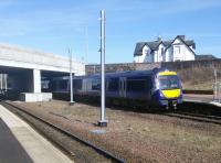 A Stirling to Glasgow service halts, as required, at the southern end of the Platform at Larbert on 20 March. The large gap between the tracks allows the OHLE masts to be installed there, rather than on the platforms which is presumably a more expensive and less safe option.<br>
<br><br>[David Panton 20/03/2018]