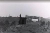 A post-1950 (full closure) image at the site of Preesall station, looking towards Knott End. The Knott End Railway had originally planned a level crossing at this point, in line with most other road crossings on the line, but the authorities insisted on this expensive bridge which added considerably to the construction costs. The embankments still stand today but the bridge has been removed and the gap infilled.<br><br>[Knott End Collection //]