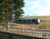 A Sunday morning service on the Borders Railway passing Falahill Village on 8 April 2018. Photographed from alongside the A7, below which the train is about to pass [see image 56265]. [Ref query 8 April 2018]<br><br>[John Furnevel 08/04/2018]
