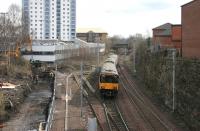 A Larkhall train leaves Hamilton Central in March 2006, running past the trap siding and onto the single line section. Work in progress alongside the line on the left will eventually provide a pedestrian link between the station and the multi storey car park on Duke Street in the centre left.<br><br>[John Furnevel 17/03/2006]