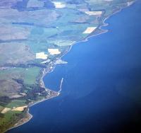 Aerial view over Cairnryan looking south showing the former Military Port. Its associated railway ran along the coastline from Leffnol (top) to Cairn Point (bottom). The triangular shape of the modern day ferry terminal can also be seen just left of centre extending out into the Loch.<br><br>[Ewan Crawford //]