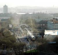 Anniesland during the constructon of the new platform - smoke rises from works. View looks south. River Clyde in background.<br><br>[Ewan Crawford //]