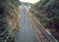 Looking south from Fairlie Tunnel to Fairlie station. A shame to cut the ground for the line and building a double track tunnel for what is now a single line - but the electrification team must have been thankful for the extra clearance.<br><br>[Ewan Crawford //1987]