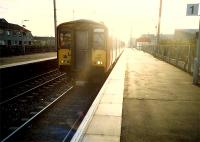 Glasgow bound, a train comes out of the sun at Stevenston.<br><br>[Ewan Crawford //1987]