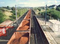 Iron ore for Ravenscraig passing through Holytown station. This was once a very fine station with Caley style building, wooden canopies and bay platforms.<br><br>[Ewan Crawford //1987]