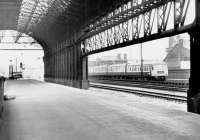 Trans-Pennine DMU passing the west end of the out-of-use Manchester Exchange in late 1970. The station's platform 3 became part of Britain's longest railway platform at 2,238 feet when it was extended east in 1929 to join up with the west end of Manchester Victoria's platform 11.<br><br>[John Furnevel 20/11/1970]