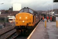 Separating 37 416 from its train at Kyle of Lochalsh in order to run round. Two walkers try to blend in with the high visibility jackets.<br><br>[Ewan Crawford 03/01/1989]