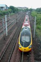 A Virgin train passes the site of the Gushetfaulds Freightliner Terminal by Larkfield Junction.<br><br>[Ewan Crawford 20/06/2006]