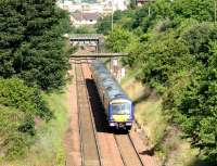 A diverted Glasgow - Edinburgh service passes through Slateford on the sub on 16 July 2006. The train has just passed below the bridge that carried the Caledonian main line out of Princes Street and which now serves as vehicle access from Merchiston to Slateford sidings and PW depot. The deck of the bridge carrying the current line between Slateford station and Haymarket can be seen just beyond.<br><br>[John Furnevel 16/07/2006]
