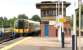 A London Waterloo - Portsmouth Harbour train arrives at Wimbledon in July 2004. The train is about to pass the Southern Railway's 1948 Art Deco <I>'Odeon'</I> style Wimbledon 'A' signal box. [See image 39797]<br><br>[John Furnevel 03/07/2004]